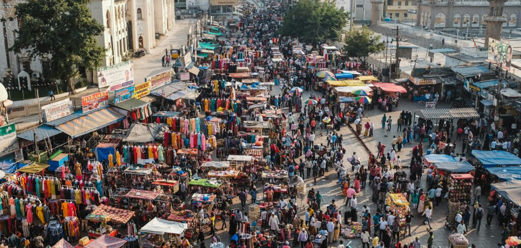 Lively urban market scene with dense crowds and street vendors.